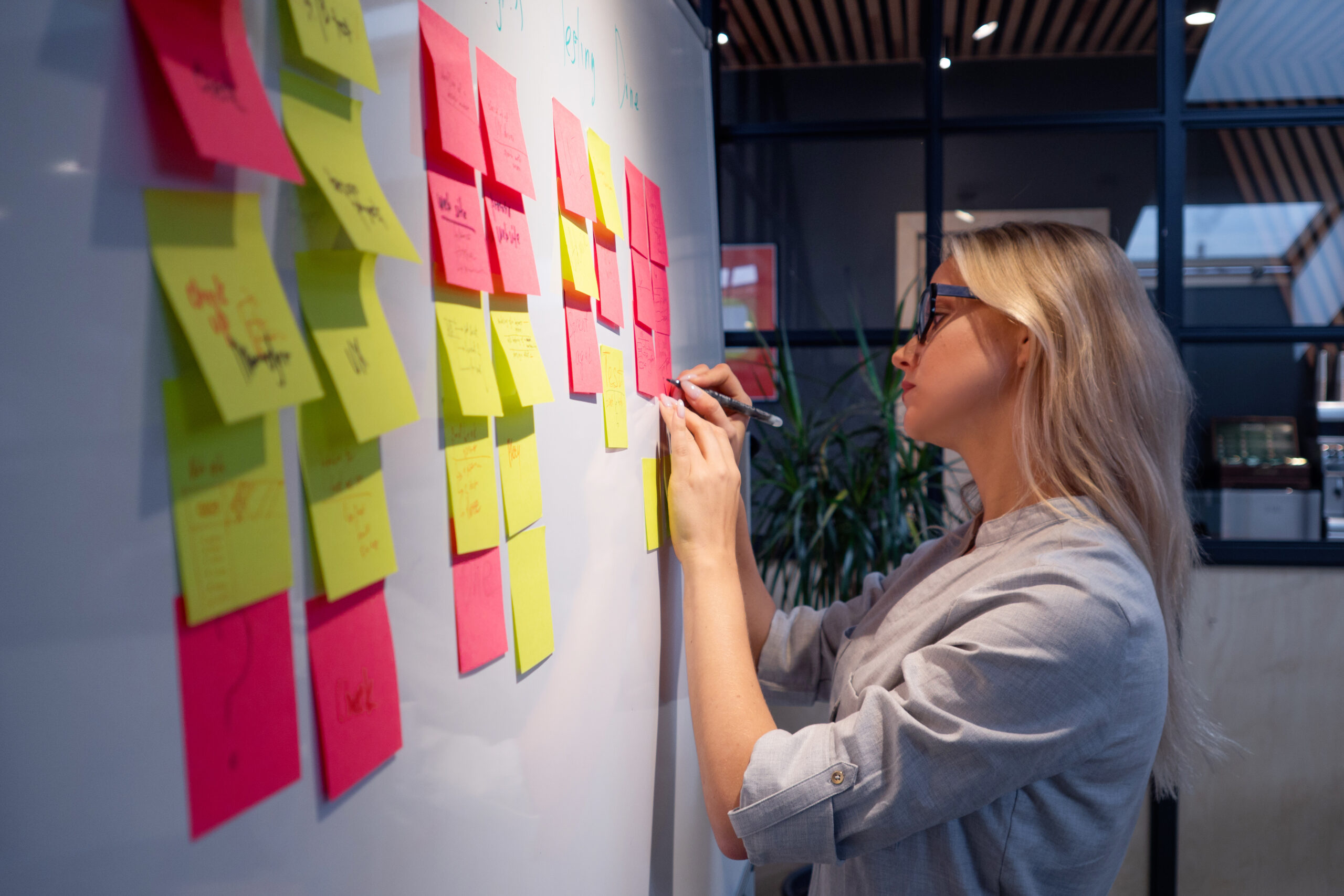 Project management, product development methodologies. A young woman makes notes